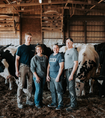 The Rokeys stand outside with Holstein dairy cows