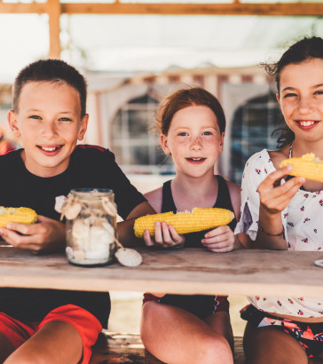 Kids eating sweet corn