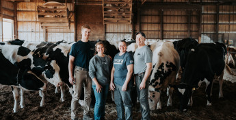 The Rokeys stand outside with Holstein dairy cows
