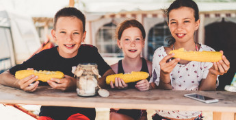 Kids eating sweet corn