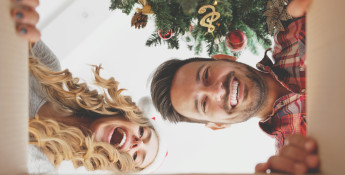 man and woman opening Christmas present