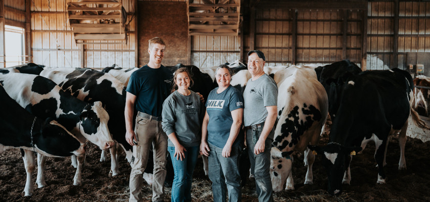 The Rokeys stand outside with Holstein dairy cows