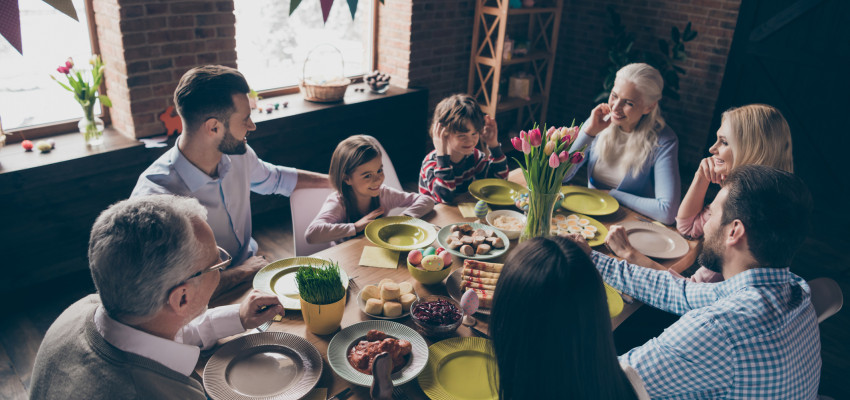 family eating Easter dinner around a table family eating Easter dinner around a table