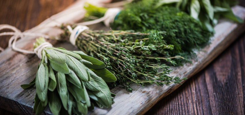 fresh herbs for cooking on wooden cutting board