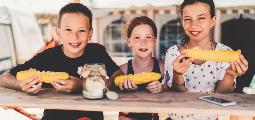 Kids eating sweet corn