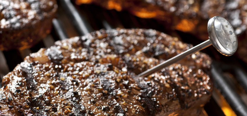 steak on a grill with meat thermometer