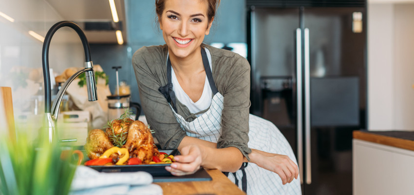 woman with cooked chicken in the kitchen