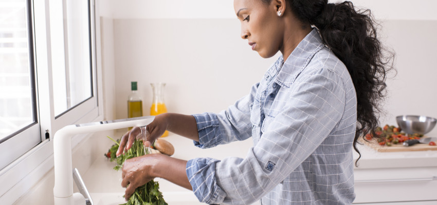 woman washing fresh herbs