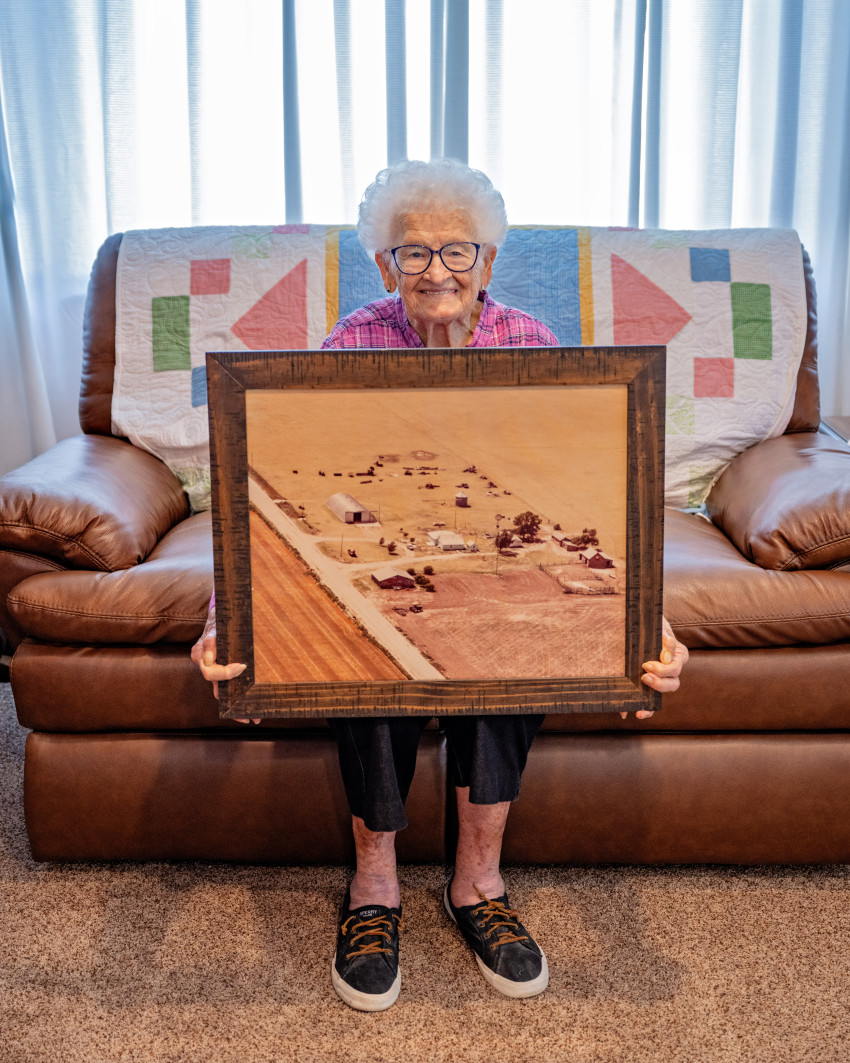 Ruby Lohman sits with an aerial image of her farm in Kearny County.