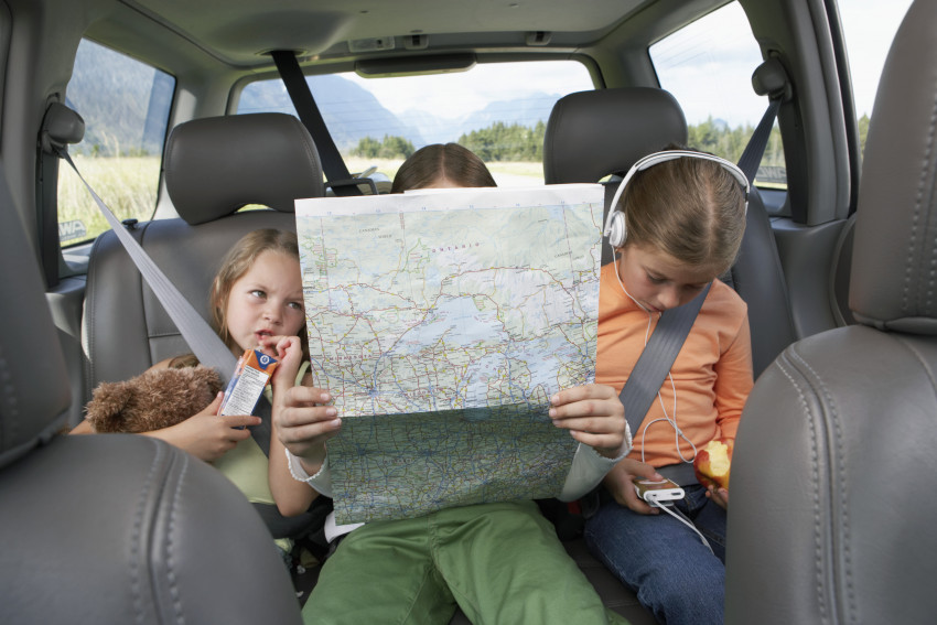 Kids on road trip looking at map