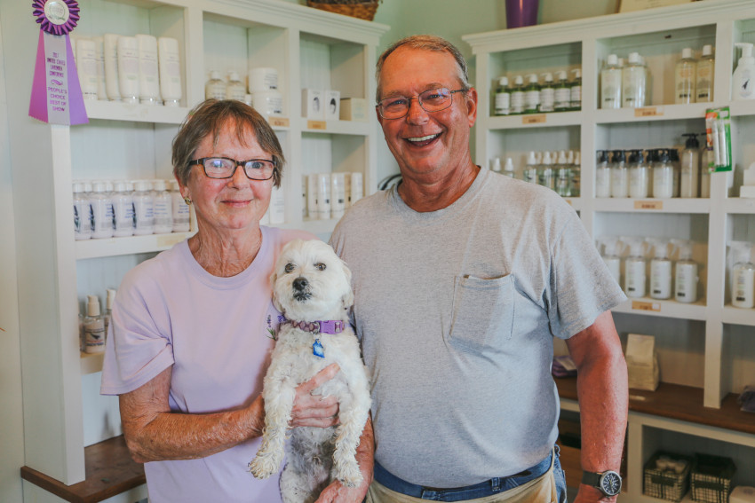 Dianne and Mike stand in their on-farm lavender shop with their dog, Augie.