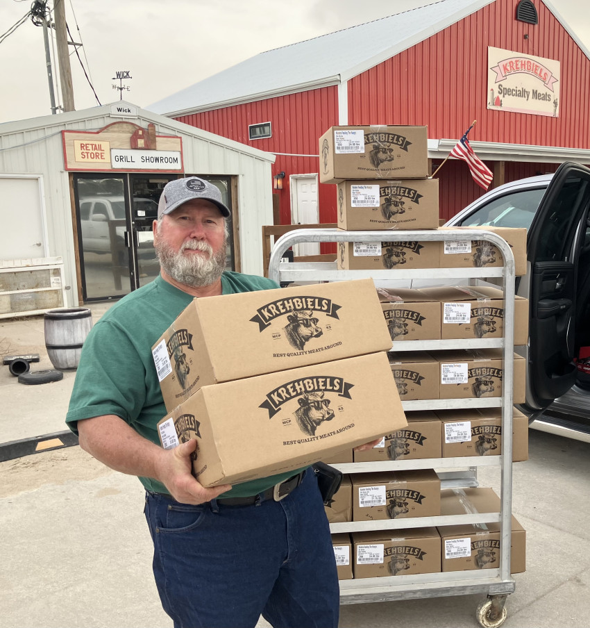 Gary Frownfelter, McPherson County Farm Bureau president carrying boxes of elk sticks. Gary Frownfelter, McPherson County Farm Bureau president carrys boxes of elk snack sticks.