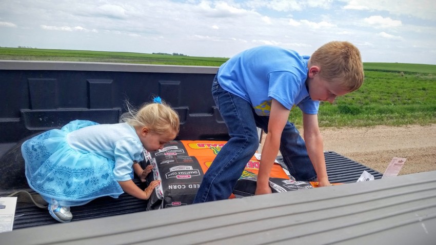 kids pushing corn seed bags