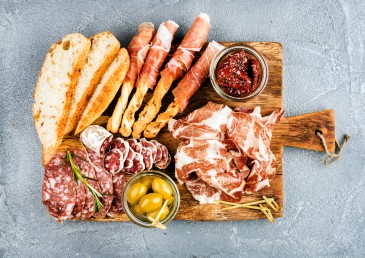 charcuterie board with meats, breads, spreads