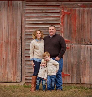 Katie Sawyer and family in front of red barn