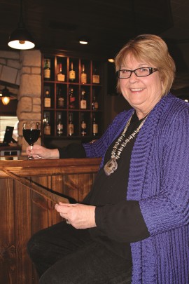 Deanna Munson, the matriarch of Munson's Prime, sitting at the bar of the restaurant.